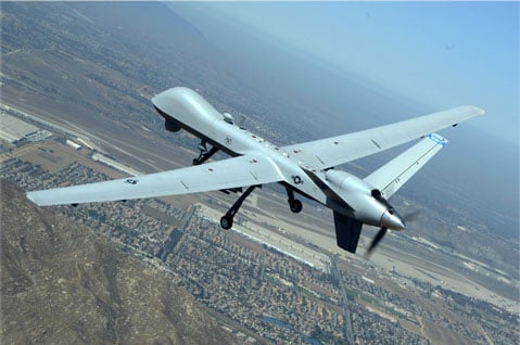MQ-9 military drone flying above an airbase