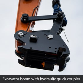 Excavator boom with hydraulic quick coupler attachment, locking pins and metal linkage for quick bucket changes