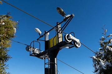 Ski mountain chairlift, intermediate supporting tower with pulley mechanism showing sheave wheels, steel rope